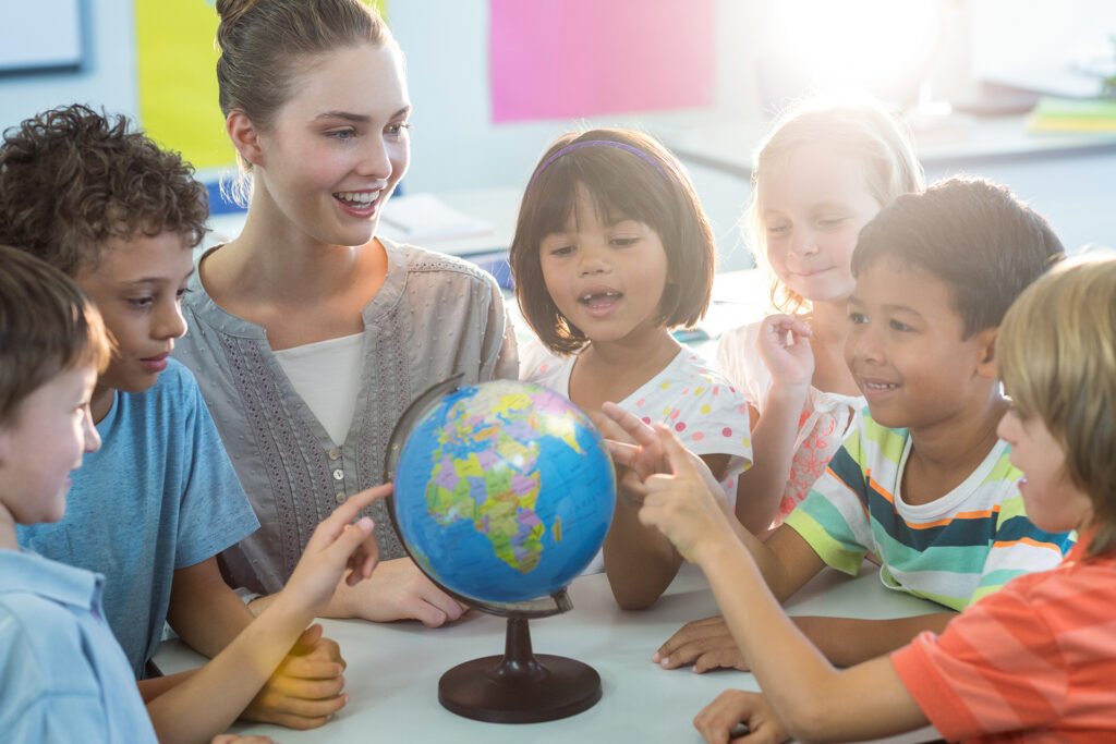 Female teacher showing globe to children